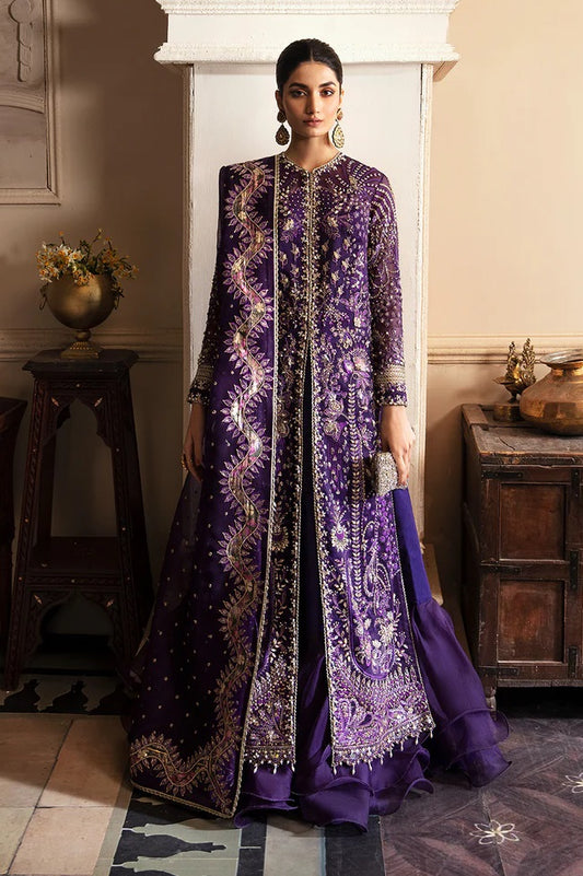 Woman wearing a traditional embroidered purple outfit in an elegant room.